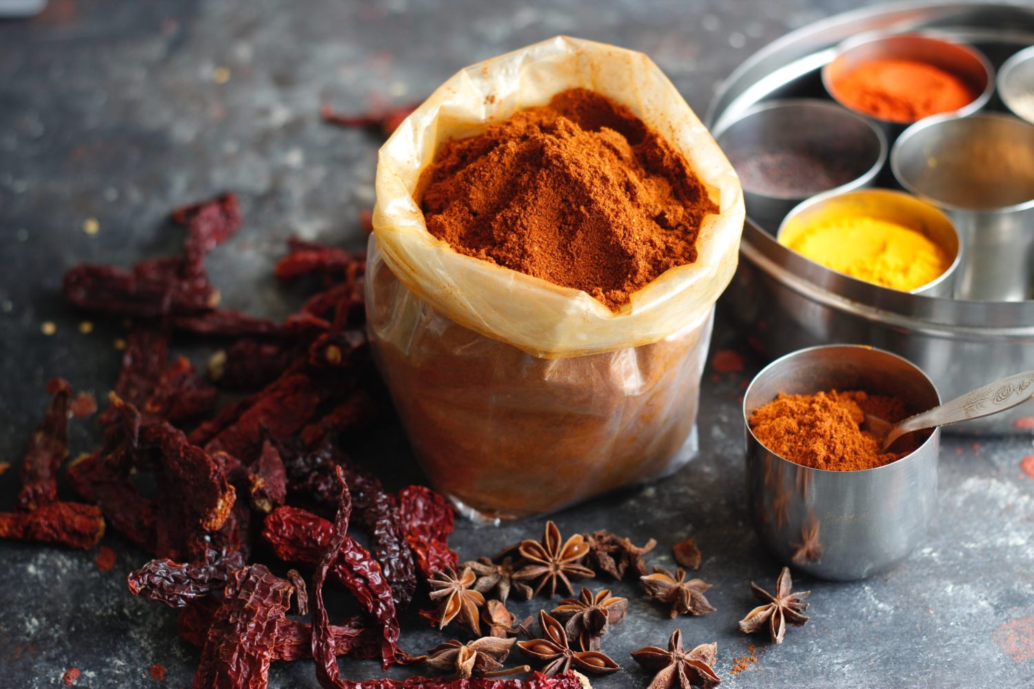 image of dried chilis and dried spices in bags and metal bowls