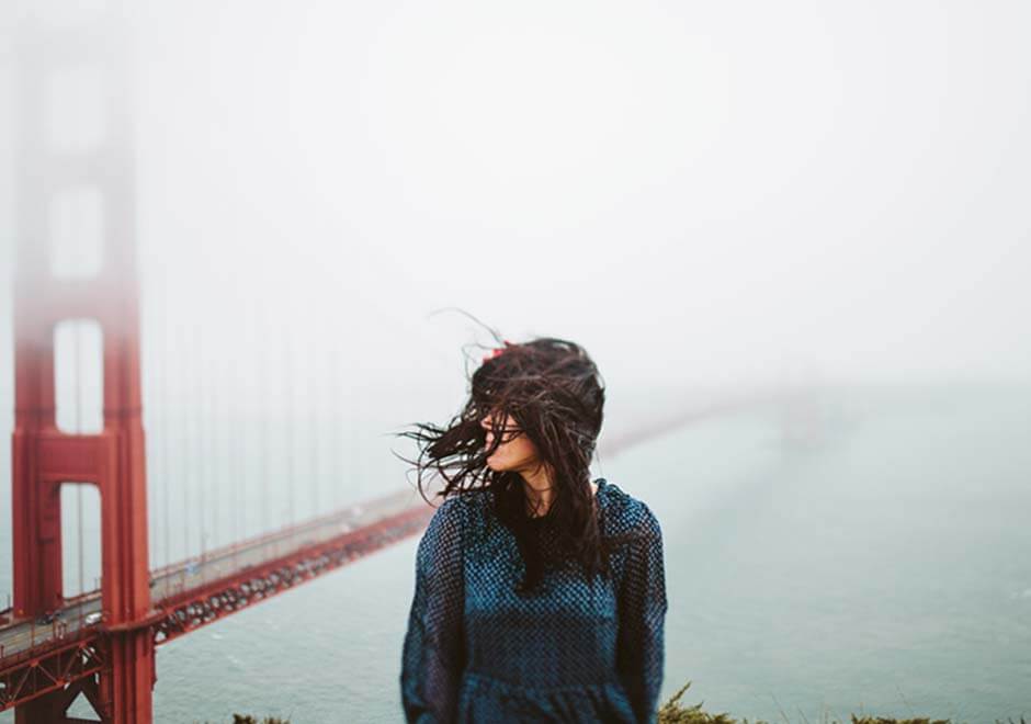 AcuGroup- an adult with long hair outside by Golden Gate Bridge